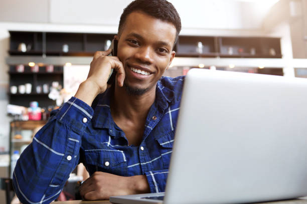 istock attractive man talking on mobile phone in cafe with laptop 656164466