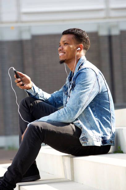 istock handsome cheerful man with cellphone and headphones outside 656164734
