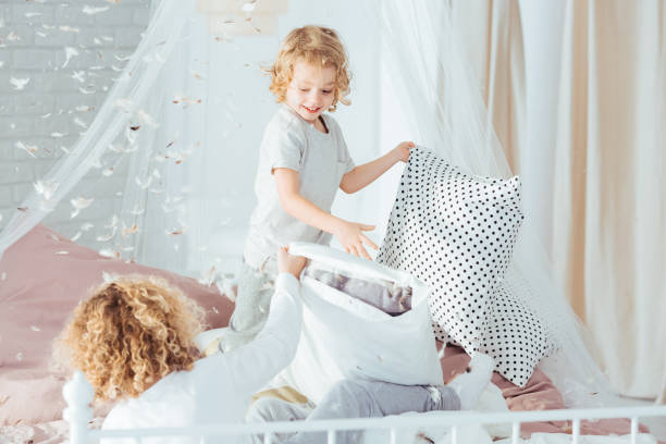 los niños pequeños tienen pelea de almohadas - lucha con almohada fotografías e imágenes de stock