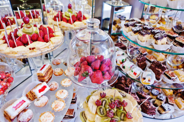 istock Strawberries under glass case at wedding reception table with different fruits, cakes and sweets. 656179360