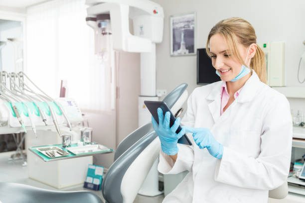 Dentist using digital tablet and ordering supplies stock photo