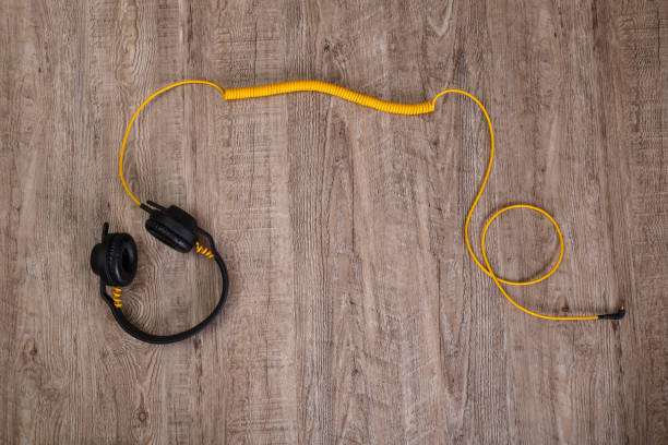 istock Headphones with yellow cable. Wooden background. 656181194