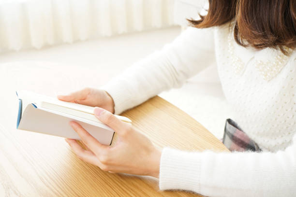 istock Young woman reading a book at home 656187420