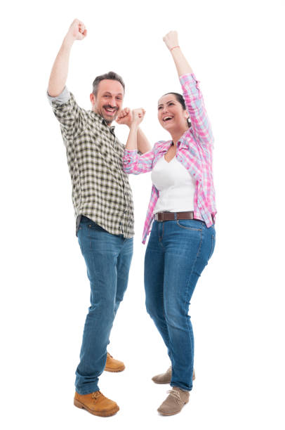 istock Joyful couple celebrating triumph and raising hands up 656189282