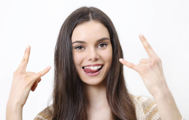 istock happy woman doing a rock and roll symbol isolated in white background 656191756