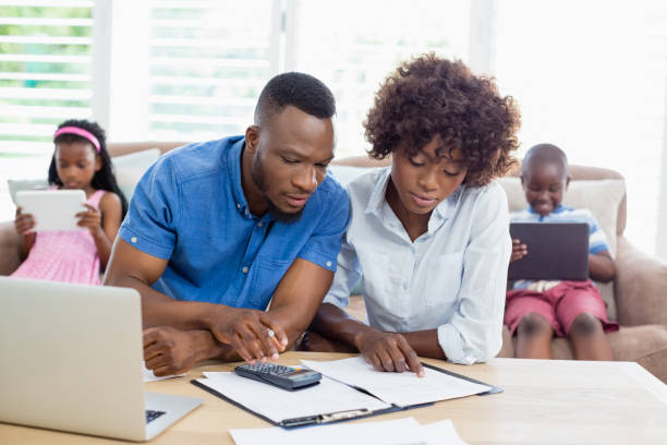istock Couple sitting at table and calculating bills 656192048