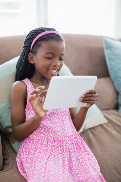 istock Girl sitting on sofa and using digital tablet in living room 656192238