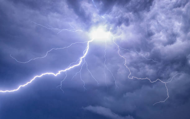 Lightning in the night sky during a thunderstorm Lightning bolts flashing out of the dark clouds in the night sky during a heavy thunderstorm. The electrical discharge of lightning happens between the clouds and a flash of lightning goes in the direction of the ground. lightning thunderstorm electricity cloud stock pictures, royalty-free photos & images