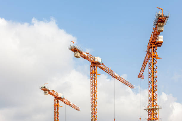 istock Three construction cranes for heavy lifting is working in construction site and clear blue sky day. 656203982