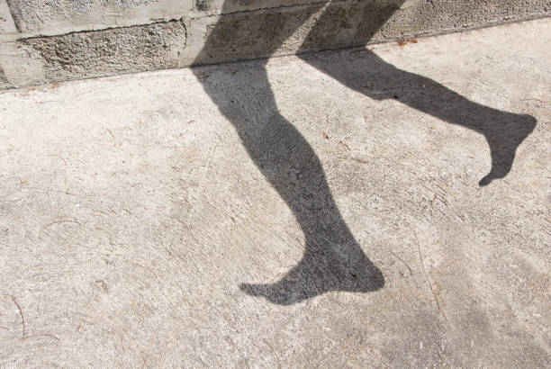 Shadow of legs on the cement floor.