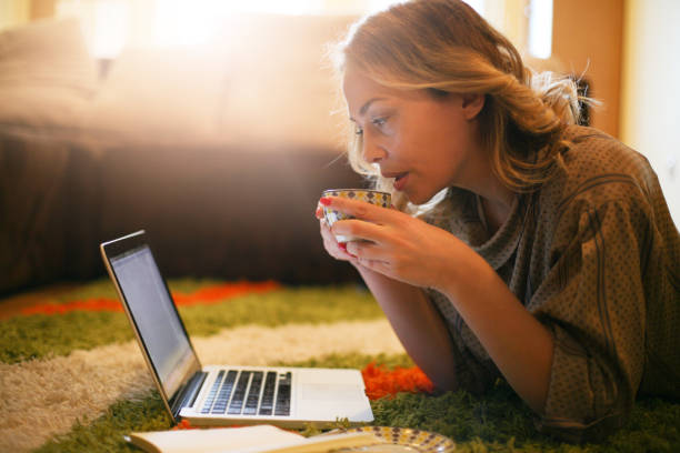 istock Blonde woman using her laptop at home. 656213700