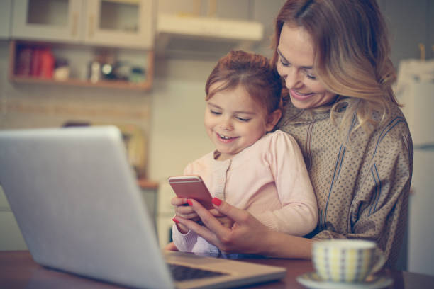 istock Mother with daughter using mobile phone. 656213772