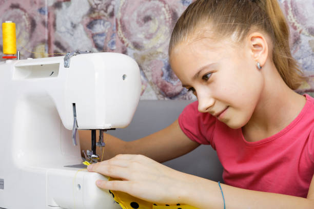 istock Girl learning to sew 656215312