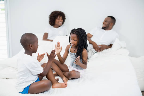 istock Kids having fun in bedroom while parents interacting in background 656218900
