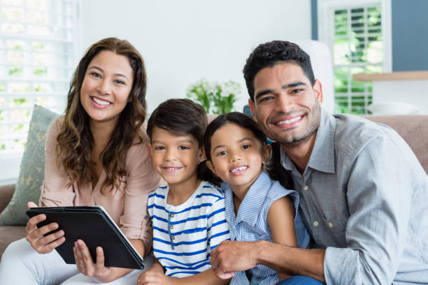 istock Parents and kids using digital tablet in living room at home 656222076