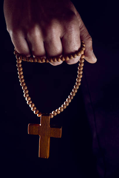 istock young man with a rosary in his hand 656234062