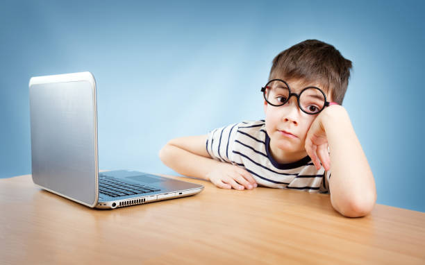 sieben jahre altes kind sitzt mit einem laptop - nerd computer learning fun stock-fotos und bilder