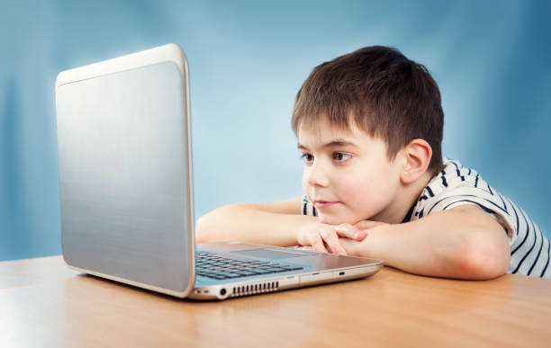 istock seven years old child sitting with a laptop 656238194