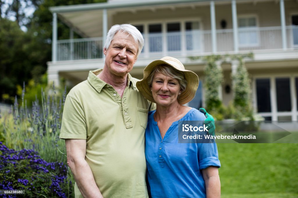 Portrait of senior couple Portrait of senior couple standing in lawn 50-59 Years Stock Photo