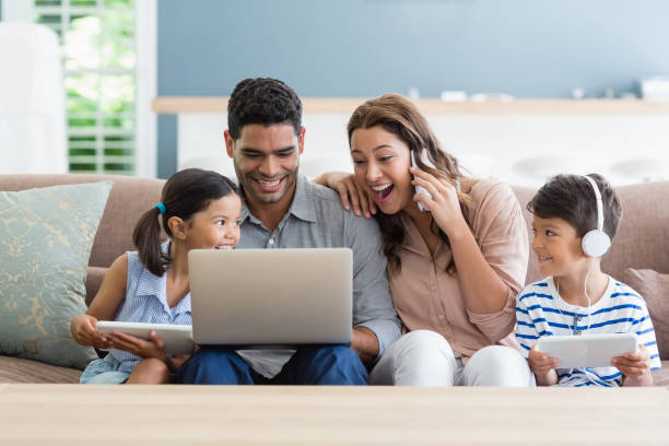 parents and kids using laptop and digital tablet in living room - parent mother music listening imagens e fotografias de stock