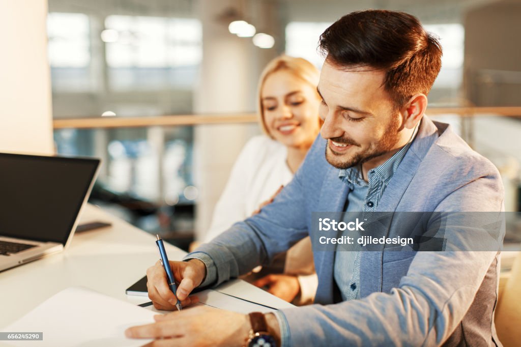 Young business couple signing a contract Financial Loan Stock Photo