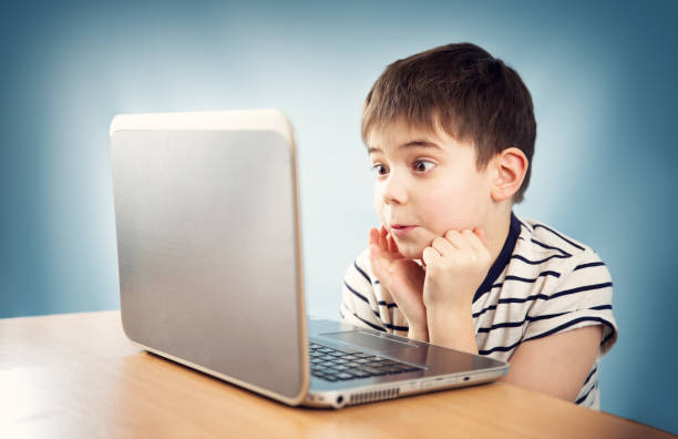 istock seven years old child sitting with a laptop 656252110