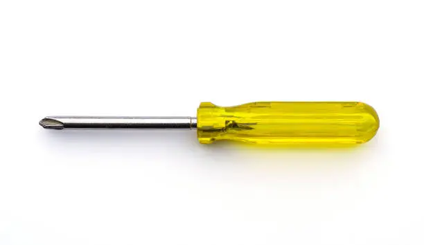 Old crosshead screwdriver with yellow plastic handle isolated on white