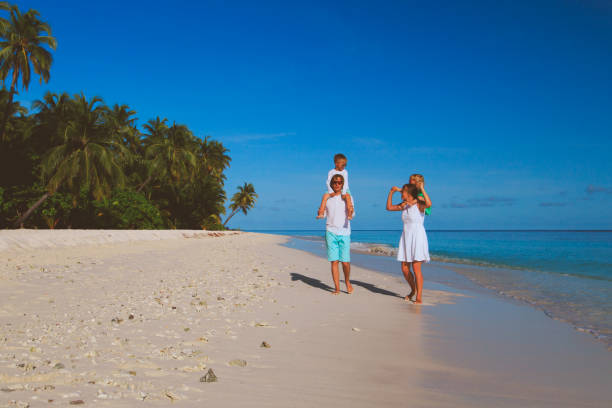 istock happy family with two kids walking on beach 656260324
