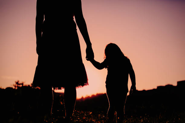 istock mother and little daughter walking in sunset nature 656263676