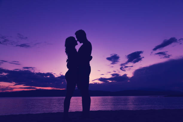 Couple enjoying on the beach in sunset / sunrise time.