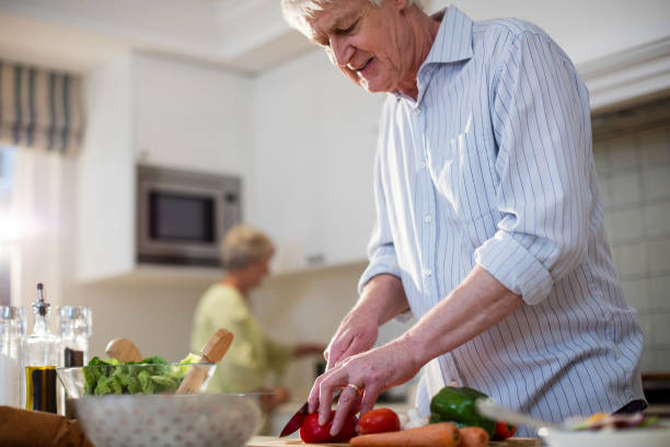 istock Senior man cutting vegetables for salad 656268364