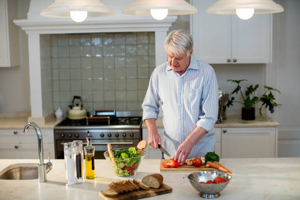 istock Senior man cutting vegetables for salad 656268442