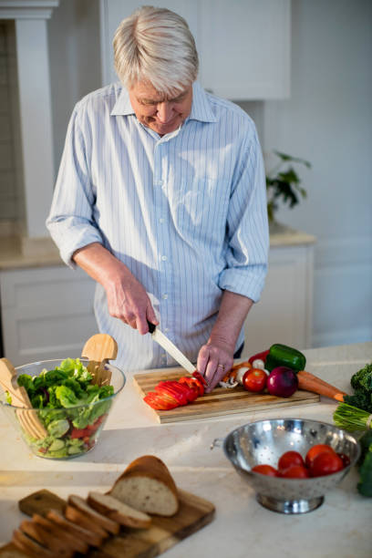 istock Senior man cutting vegetables for salad 656268548