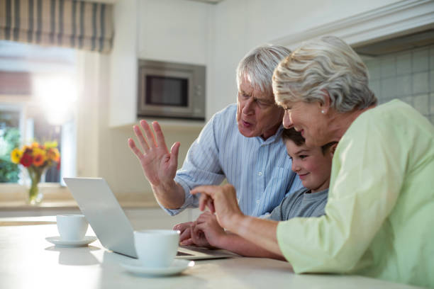 wnuk za pomocą laptopa z dziadkami - grandparent using computer laptop dining table zdjęcia i obrazy z banku zdjęć