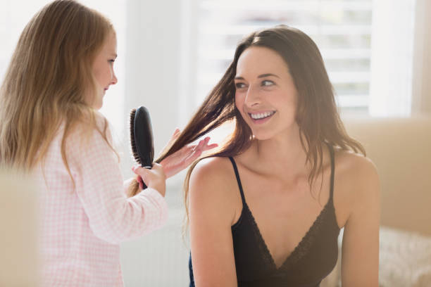 Daughter brushing mothers hair Daughter brushing mothers hair brushing hair stock pictures, royalty-free photos & images