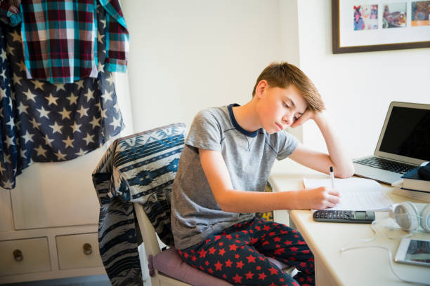 boring homework pictures Bored boy doing math homework at desk in bedroom Bored boy doing math homework at desk in bedroom boring homework twelve stock pictures, royalty-free photos & images