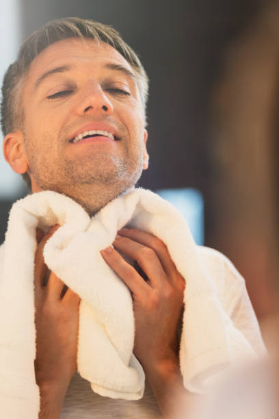 istock Man wiping neck at bathroom mirror 656287793