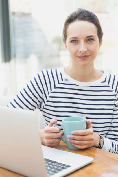 istock Portrait confident woman drinking coffee at laptop 656287803