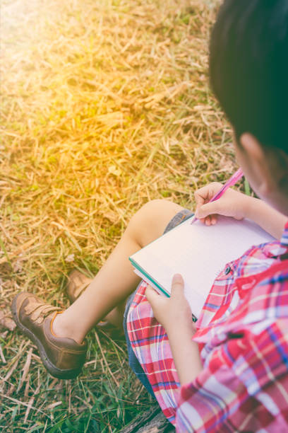 istock Back view. Boy writing on book. Education concept. Vintage style. 656292548
