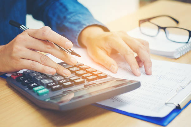 istock Financial data analyzing hand writing and counting on calculator in office on wood desk 656292694