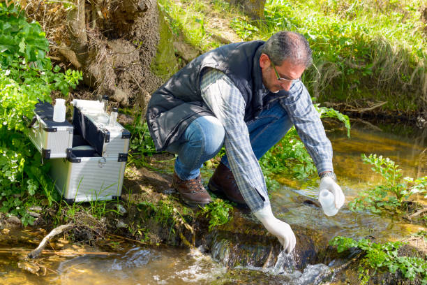 View of a Biologist take a sample in a river. stock photo