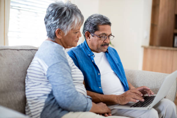 istock Senior couple using laptop in living room 656302942