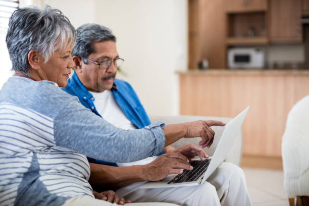 istock Senior couple using laptop in living room 656304482