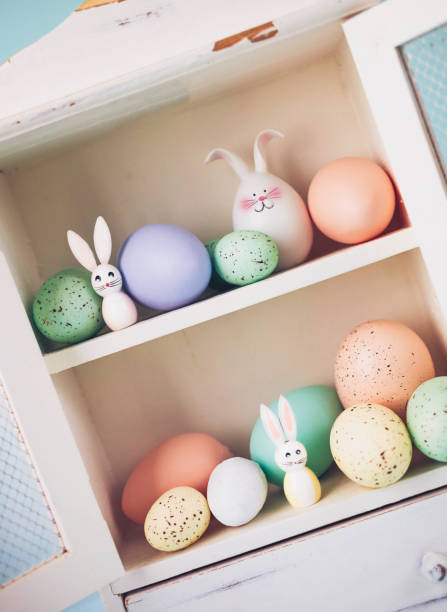 Easter collection of eggs and rabbits in white cabinet