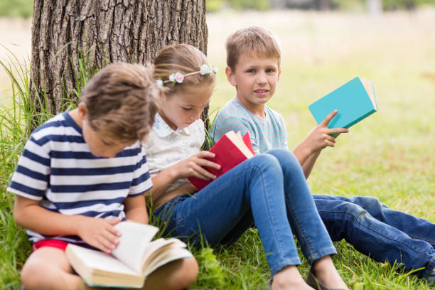 istock Kids reading books in park 656329682