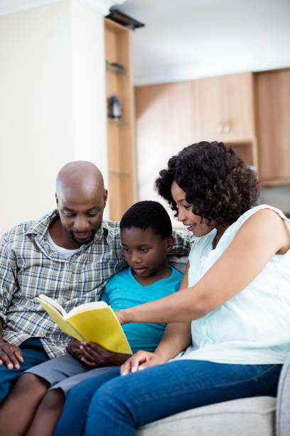 istock Parents reading book with their son in living room 656332108