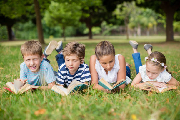 istock Kids lying on grass and reading books 656336124
