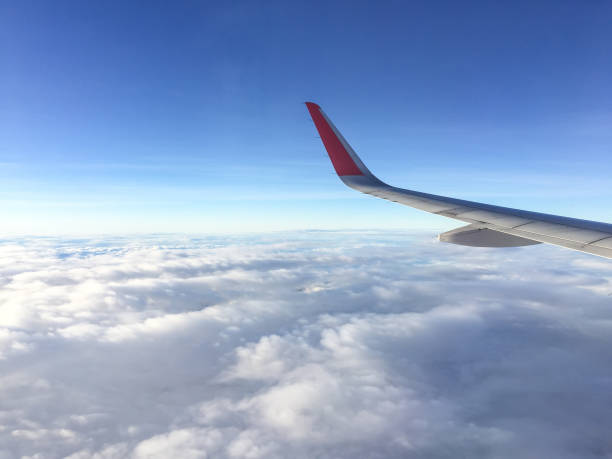 istock Wing of airplane flying above the clouds in the sky 656345802
