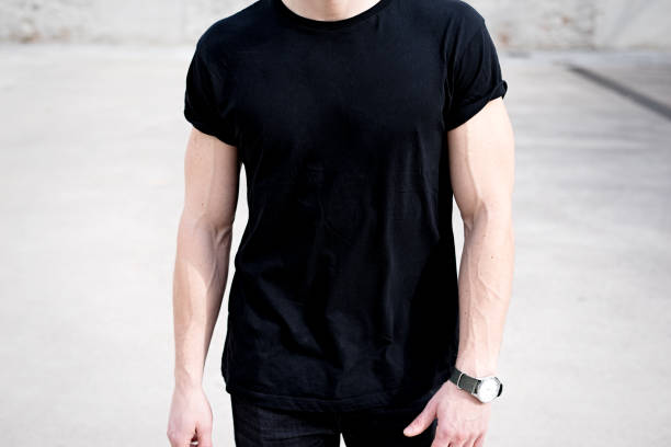 detailansicht von jungen muskulösen mann tragen schwarze t-shirt und jeans posiert vor. leeren hintergrund. hotizontal mock-up. - hotizontal stock-fotos und bilder