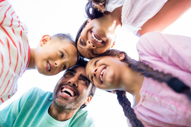 istock Happy family forming huddle in park 656350364